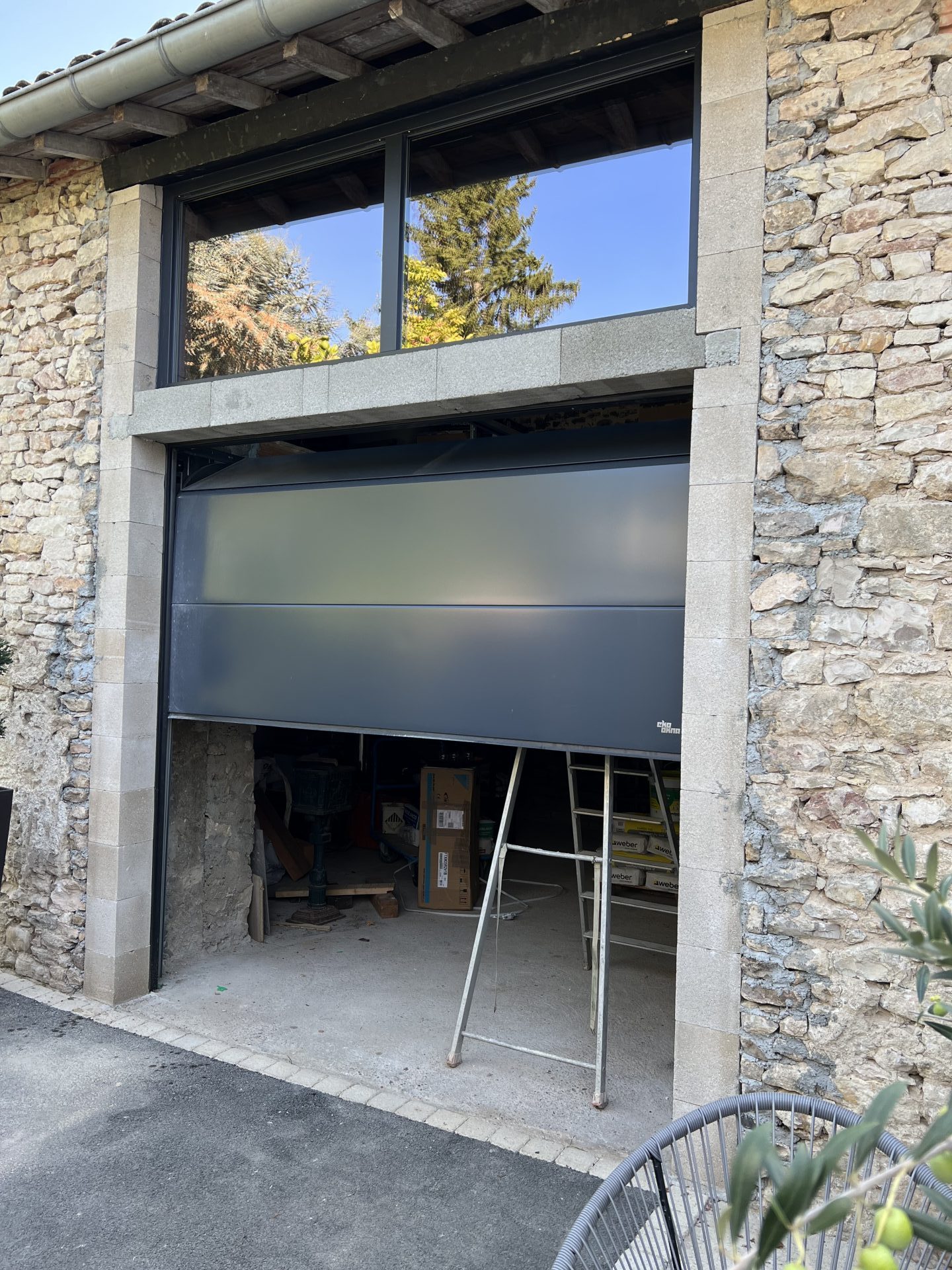 Porte de garage sectionnelle motorisée en rénovation de bâtisse en pierre