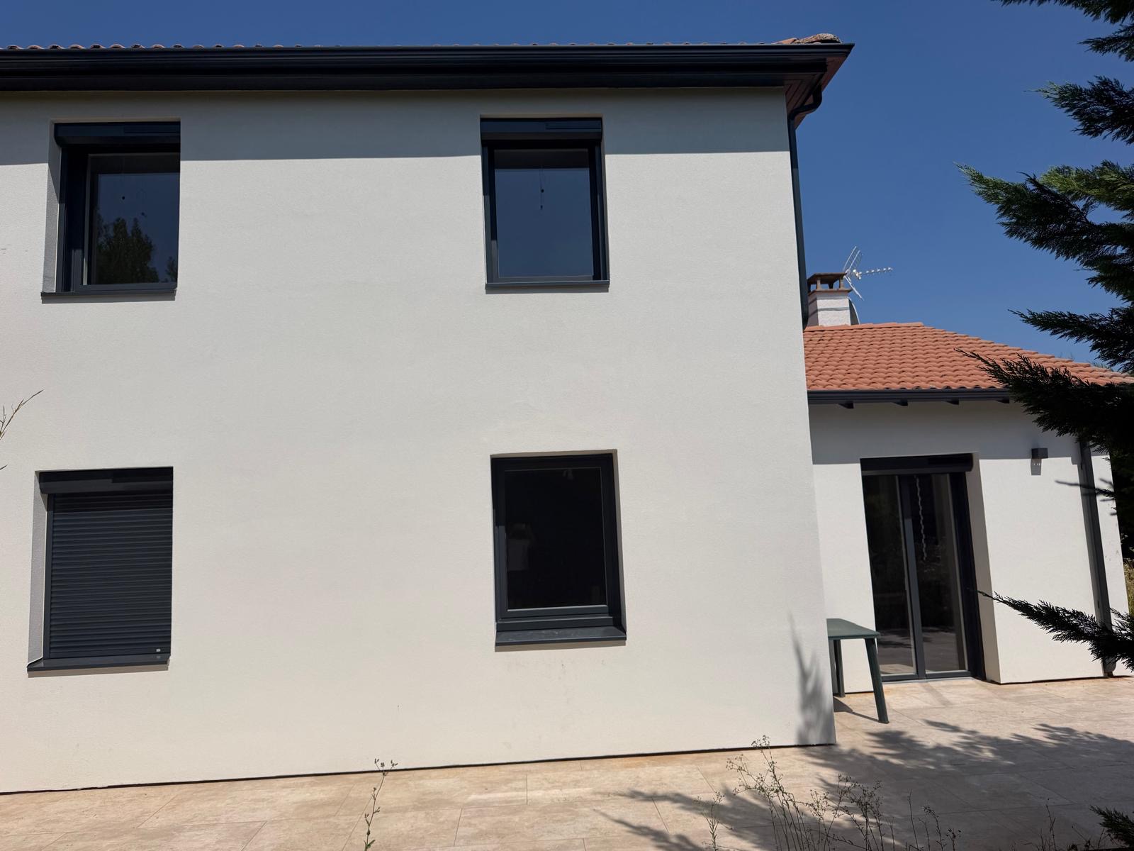 Façade avec fenêtres gris anthracite et volets roulants
