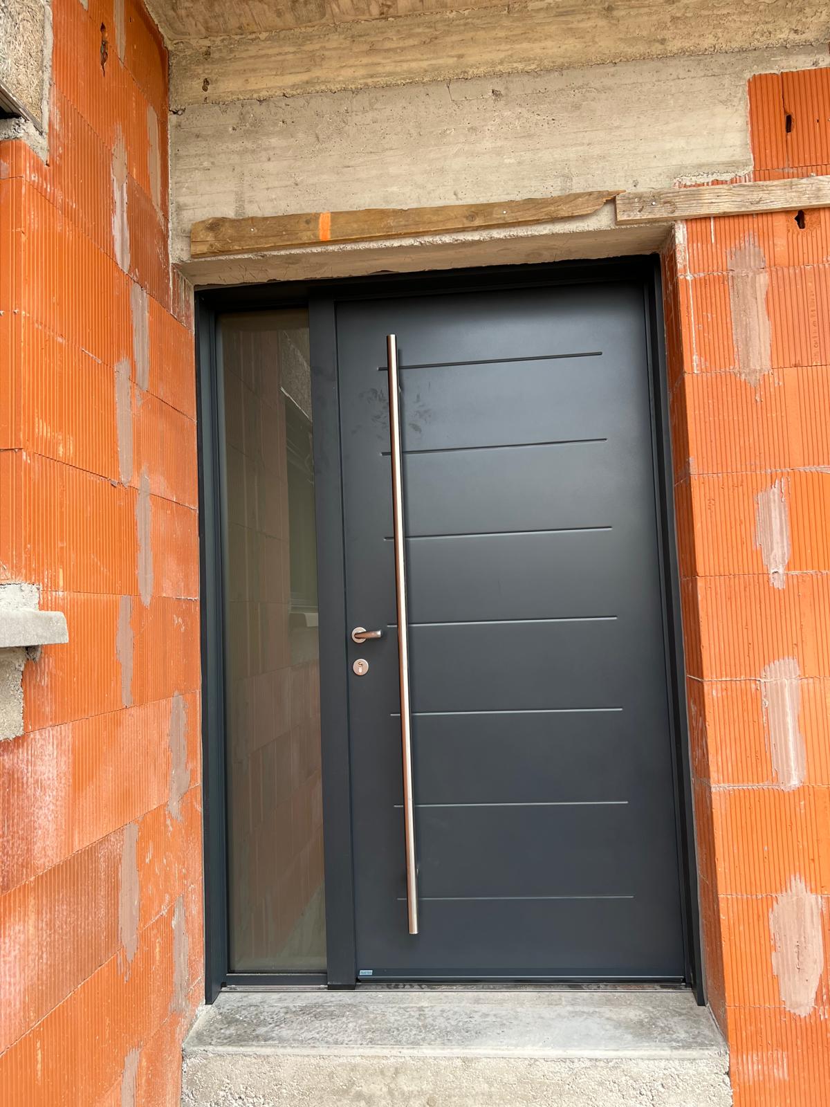 Porte d'entrée aluminium anthracite avec barre de tirage inox en construction neuve